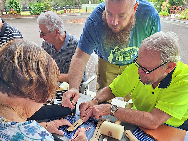 Members watching how to mark up and punch holes.